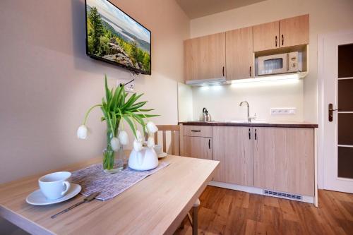 a kitchen with a wooden table with a vase on it at Apartmány Tatra in Jáchymov