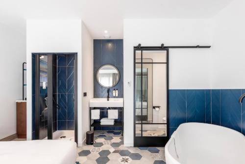 ein Bad mit einem Waschbecken und einem Spiegel in der Unterkunft Victoria Boutique Hotel in Arcachon