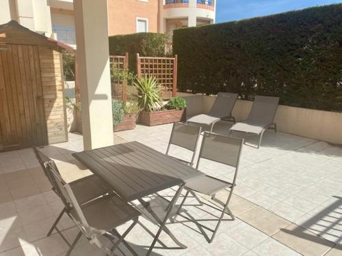 - un ensemble de chaises et d'une table sur une terrasse dans l'établissement Appt 2 pièces Port Fréjus - méga terrasse + garage, à Fréjus