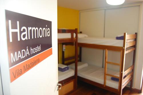 a group of bunk beds in a room with a sign at MADÁ hostel in Sao Paulo