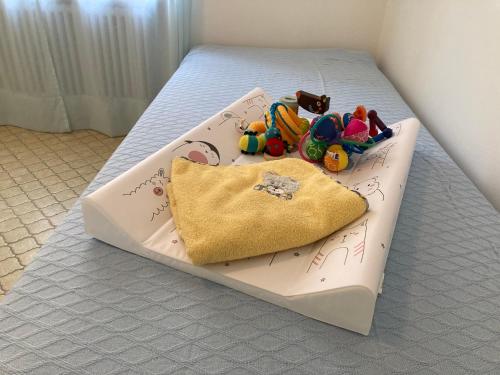 a bed with a pillow and toys on it at Appartamento con giardino al Melograno in Locarno