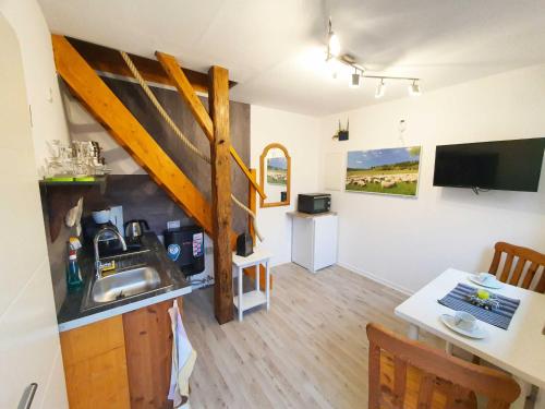 una cucina e una sala da pranzo con lavandino e tavolo di Ferienhaus Rhöner Auszeit a Kaltenwestheim
