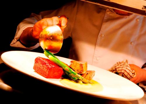 a person holding a spoon over a plate of food at Coul House Hotel in Contin