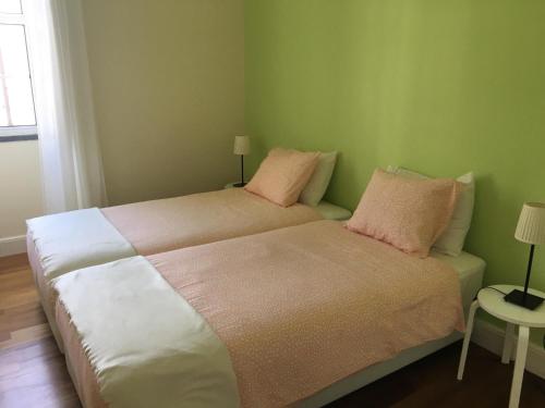 um quarto com uma cama grande e almofadas cor-de-rosa em Summer house with BBQ and Garden em Horta