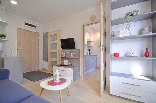 - un salon avec un canapé bleu et une table dans l'établissement Apartamenty Bryza - Kwartał Róży Wiatrów, à Świnoujście