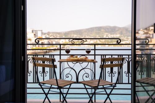 a table and chairs on a balcony with a view at Casa Porto Boutique Hotel - Adults only in Agios Nikolaos