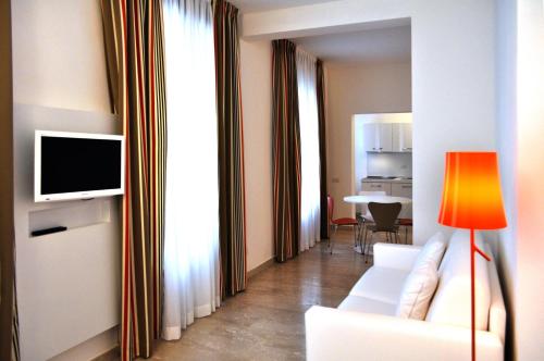 ミラノにあるBB ホテルズ アパートホテル ボッコーニのリビングルーム(白いソファ、テレビ付)