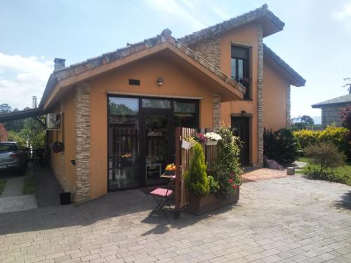 una pequeña casa con una silla rosa delante en EntrePontes, en Tui