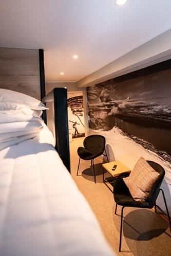 a bedroom with a bed and two chairs and a table at Breidablikk Guesthouse in Narvik
