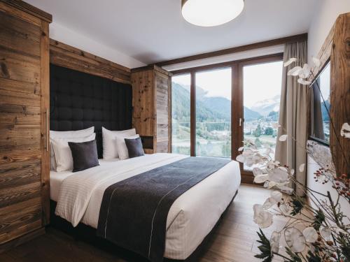 una camera da letto con un grande letto con una grande finestra di VAYA St Anton a Sankt Anton am Arlberg