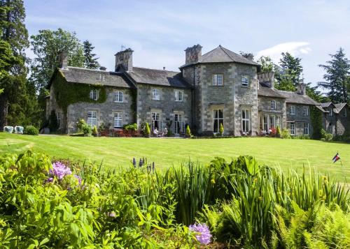an old stone house with a large yard at Coul House Hotel in Contin