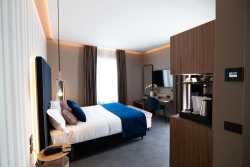Habitación de hotel con cama y escritorio en 3T Boutique Hotel en Ivrea