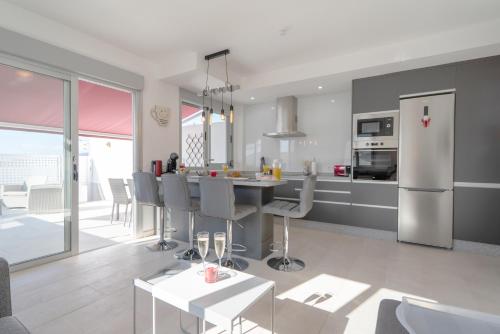 a kitchen and living room with a table and a refrigerator at Luxurious apartment with large terrace and sea views in Tabaiba
