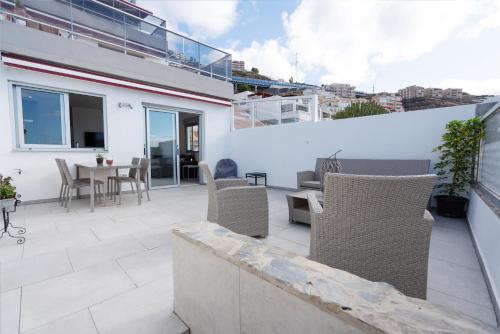 a patio with chairs and a table on a building at Luxurious apartment with large terrace and sea views in Tabaiba
