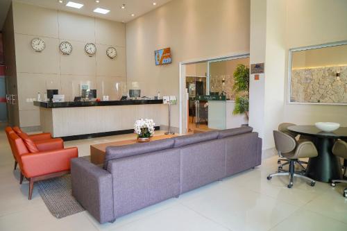 a lobby with a couch and chairs and a counter at Transamerica Fit Vitória Reta da Penha in Vitória
