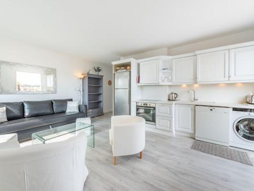 uma cozinha e sala de estar com armários brancos em Apartment Turquoise-8 by Interhome em Cavalaire-sur-Mer