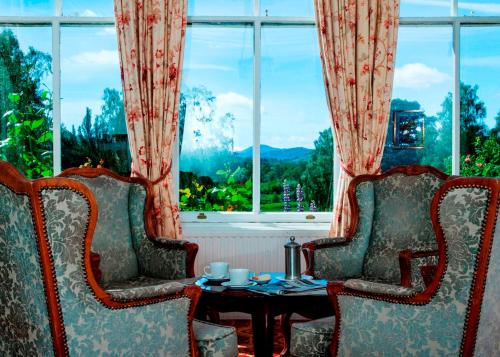 two chairs and a table in front of a window at Coul House Hotel in Contin