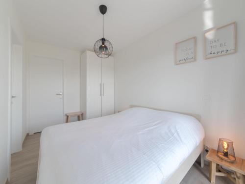 a white bedroom with a white bed and a lamp at Apartment Railway to the Beach by Interhome in Blankenberge