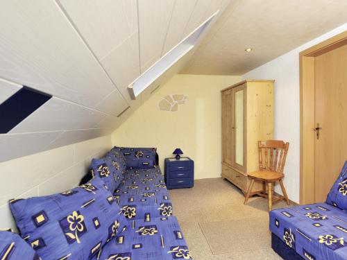 um quarto no sótão com uma cama e uma cadeira em Familien-Ferienwohnung Haustein em Königswalde