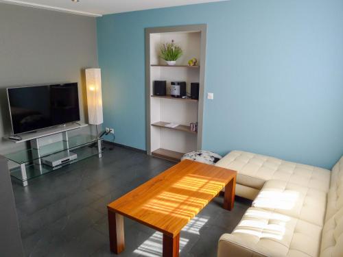 Apartment Schlieregg by Interhome في Hirzel: غرفة معيشة مع أريكة بيضاء وطاولة