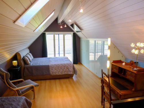 Schlafzimmer im Dachgeschoss mit einem Bett und einem Tisch in der Unterkunft Apartment Schlieregg by Interhome in Hirzel
