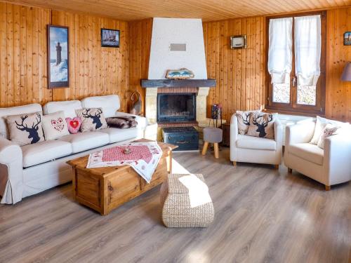 uma sala de estar com sofás brancos e uma lareira em Chalet Chalet Tsi-No by Interhome em Gryon