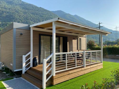 eine kleine Hütte mit einer Veranda und einer Terrasse in der Unterkunft Holiday Home Bungalow Isola Premium by Interhome in Gudo