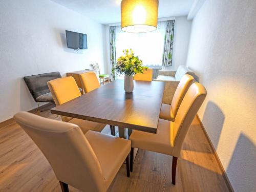 een eetkamer met een houten tafel en gele stoelen bij Apartment Inntalerhof-3 by Interhome in Tösens