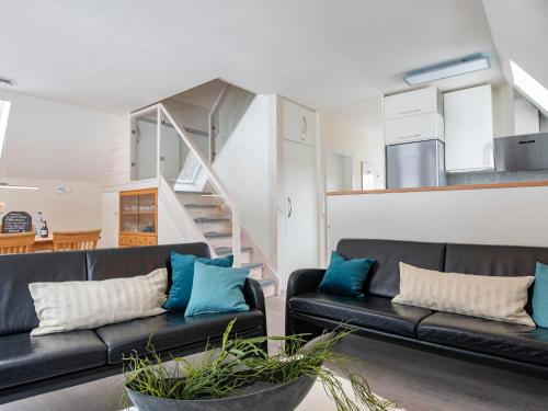 sala de estar con 2 sofás negros y almohadas azules en Holiday Home Ferienhaus Bude 92 by Interhome en Bad Arolsen