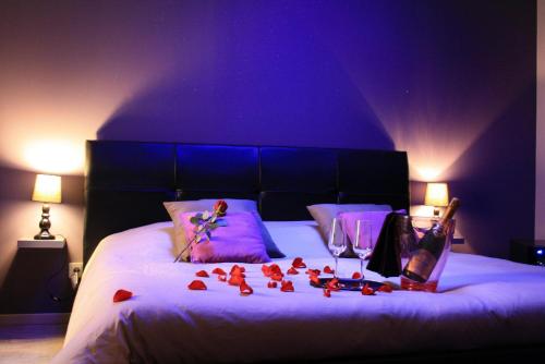 a bedroom with a bed with red roses on it at Le Loveappart in Pézenas