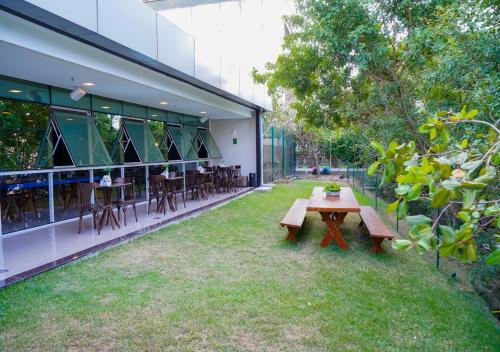 a patio with benches and tables in a building at Transamerica Fit Vitória Reta da Penha in Vitória
