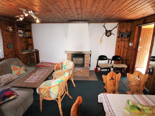 - un salon avec une cheminée, une table et des chaises dans l'établissement Chalet Vesec by Interhome, à Vesec