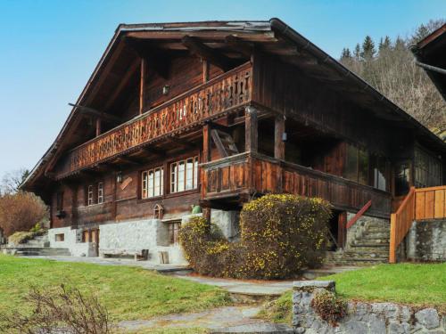 a large wooden building with windows on a hill at Chalet Chalet Pierre Fleur by Interhome in Gryon