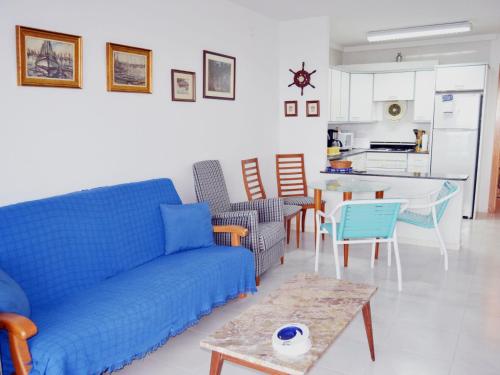 - un salon avec un canapé bleu et une table dans l'établissement Apartment Ordre de Malta by Interhome, à Sant Carles de la Ràpita