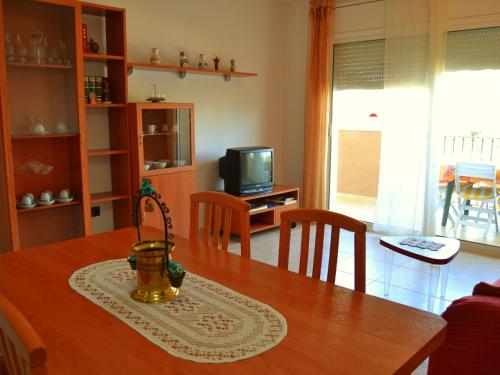 eine Küche und ein Wohnzimmer mit einem Tisch und einem TV in der Unterkunft Apartment Apartamentos Golden Beach by Interhome in Sant Carles de la Ràpita