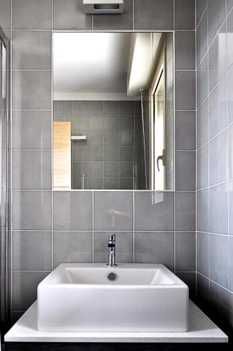 a bathroom with a white sink and a mirror at BB Hotels Aparthotel Bicocca in Milan
