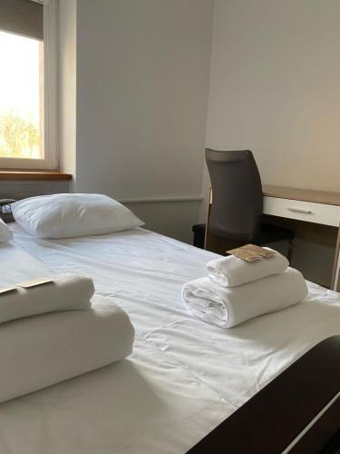 a bedroom with two white towels on a bed at V15 Apartment in Druskininkai