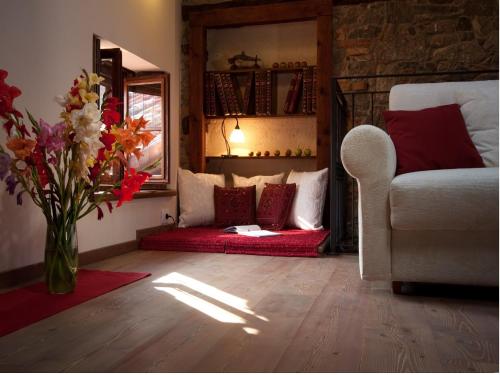 a living room with a vase of flowers and a couch at Affittacamere Valnascosta in Faedis