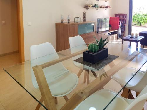 a dining room with a glass table and white chairs at Apartment Vila del Far by Interhome in Sant Carles de la Ràpita