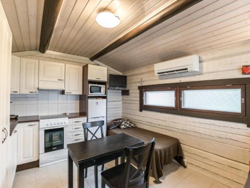 a kitchen with a table and a dining room at Holiday Home A-sauna by Interhome in Pori