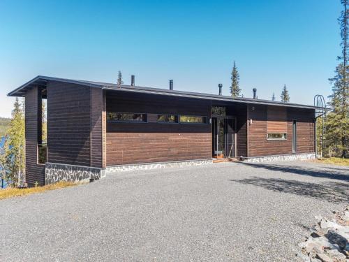un edificio de ladrillo marrón con aparcamiento en Holiday Home Holy lake rantasauna by Interhome en Niskala