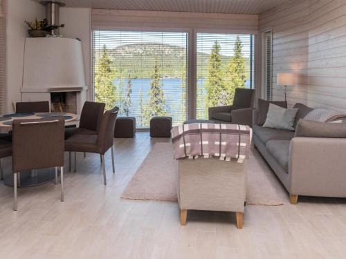 uma sala de estar com um sofá, uma mesa e cadeiras em Holiday Home Holy lake rantasauna by Interhome em Niskala