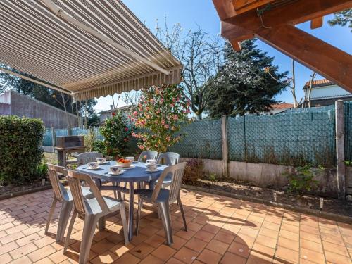 a patio with a table and chairs on a brick patio at Holiday Home Résidence Les Lauriers by Interhome in Meschers-sur-Gironde