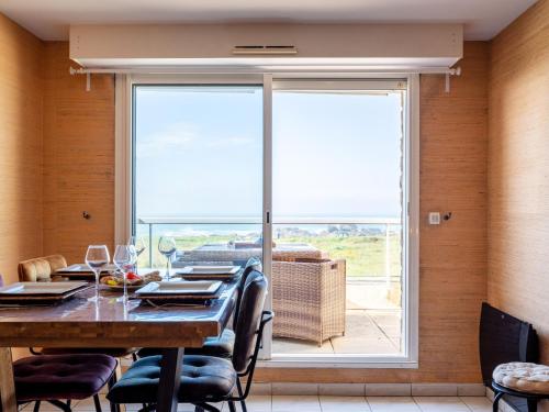 une salle à manger avec une table et une grande fenêtre dans l'établissement Apartment Er Palouen by Interhome, à Quiberon