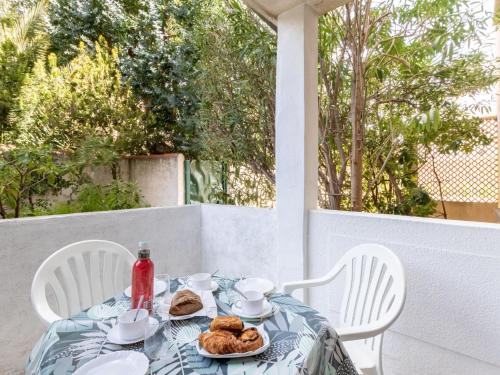 une table avec une assiette de nourriture assise sur une terrasse couverte dans l'établissement Apartment Super Plage-4 by Interhome, à Saint-Cyr-sur-Mer