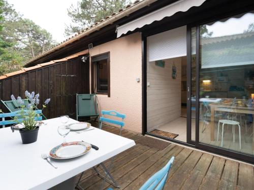 d'une terrasse avec une table blanche et des chaises. dans l'établissement Holiday Home Les Pins-12 by Interhome, à Lacanau-Océan