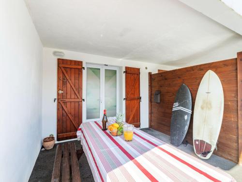 a room with a table with a surfboard on the wall at Apartment Jardins de Maignon by Interhome in Anglet