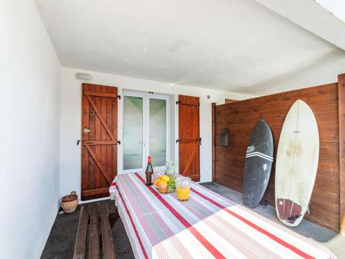 une chambre avec une table et une planche de surf sur le mur dans l'établissement Apartment Jardins de Maignon by Interhome, à Anglet