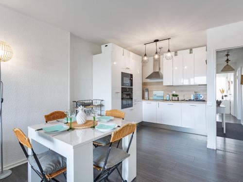 une cuisine et une salle à manger avec une table et des chaises blanches dans l'établissement Apartment mille sabords-14 by Interhome, à Capbreton