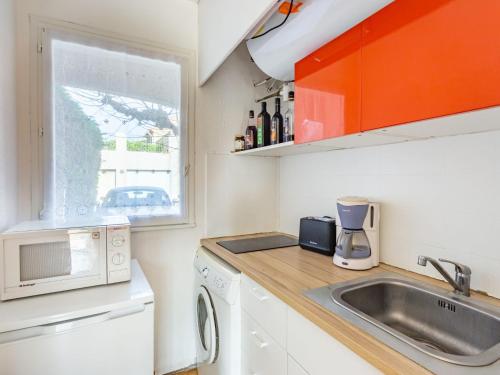 une petite cuisine avec un évier et un micro-ondes dans l'établissement Studio L'Olivado by Interhome, à Carqueiranne